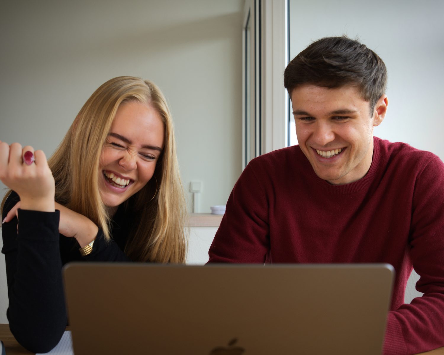 Markus Johnsen og en gymnasieelev griner sammen over en opgave på computeren